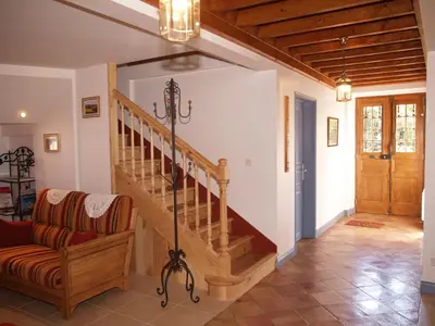 a living room with a staircase and a chair at Le Majeste in Juzes
