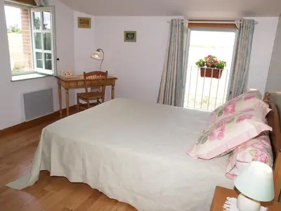 a bedroom with a bed and a desk and a window at Le Majeste in Juzes