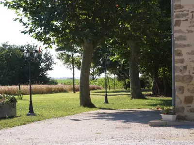 a park with trees and lights in the grass at Le Majeste in Juzes