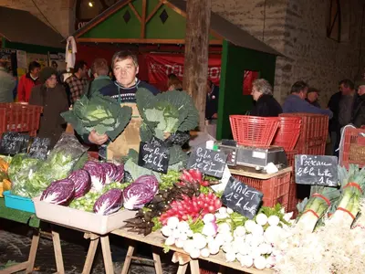 a man standing next to a table with vegetables on it at Le Majeste in Juzes