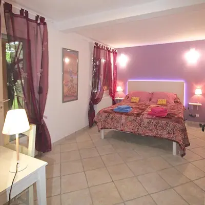 a bedroom with a bed with red curtains at Gîte des Orgues d'Ille les Eucalyptus in Ille-sur-Têt