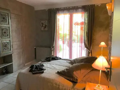 a bedroom with a large bed and a window at Gîte des Orgues d'Ille les Agaves Canigou in Ille-sur-Têt