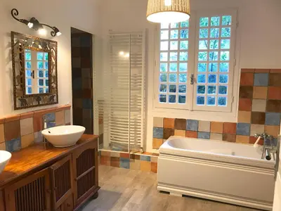 a bathroom with two sinks and a tub and a mirror at Gîte des Orgues d'Ille les Agaves Canigou in Ille-sur-Têt