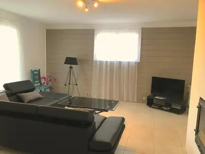 a living room with a black couch and a television at Gîte des Orgues d'Ille les Agaves Canigou in Ille-sur-Têt