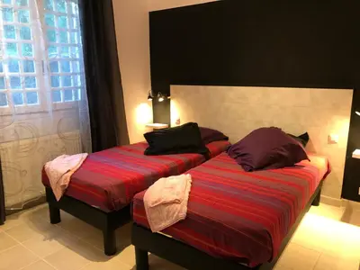 a bedroom with two beds and a window at Gîte des Orgues d'Ille les Agaves Canigou in Ille-sur-Têt