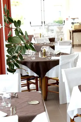 a restaurant with tables with glasses and a plant at Logis Hôtel - Auberge du Pastel - Hôtel 3 étoiles et Restaurant in Nailloux