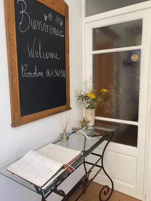 a glass table in front of a window with a chalkboard at Gîte Du Bourrelier in Boutenac