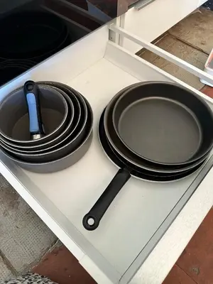 a black plate and a spatula sitting on a drawer at Gîte Du Bourrelier in Boutenac