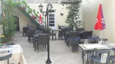 a restaurant with tables and chairs and a flag at Logis Hotels - Hôtel Le Boulevard in Mazamet