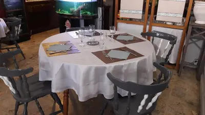 a table with a white table cloth and wine glasses at Logis Hotels - Hôtel Le Boulevard in Mazamet