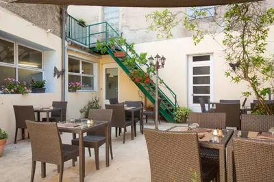 an outdoor restaurant with tables and chairs and a staircase at Logis Hotels - Hôtel Le Boulevard in Mazamet