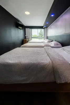 a bedroom with two beds and a window at Hôtel La Rocade in Pamiers