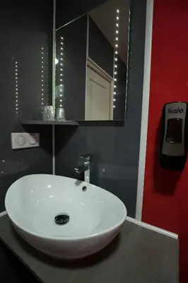 a bathroom with a white sink and a mirror at Hôtel La Rocade in Pamiers