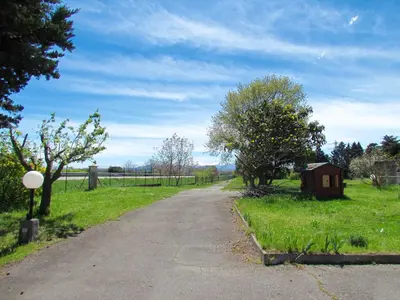 a dirt road in a field with trees and a fence at Hôtel La Rocade in Pamiers
