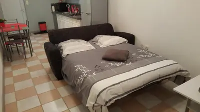 a bed in a small room with a table at Gite Pourquoi Pas in Montégut-Lauragais