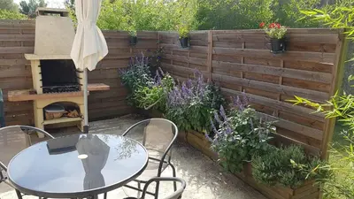 a patio with a table and chairs and some plants at Gite Pourquoi Pas in Montégut-Lauragais