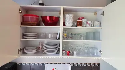 a cupboard filled with plates and dishes in a kitchen at Gite Pourquoi Pas in Montégut-Lauragais