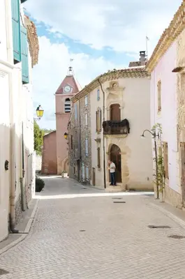 a person standing in an alley with a clock tower at Village Castigno - Wine Hotel & Resort in Assignan