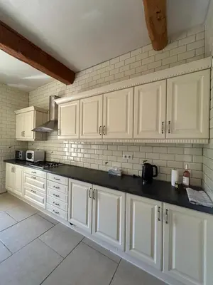 a kitchen with white cabinets and black counter tops at Domaine Les Salices in Azille