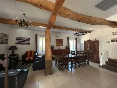 a living room with a table and a dining room at Domaine Les Salices in Azille