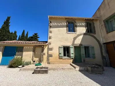 a large building with a green door in a yard at Domaine Les Salices in Azille