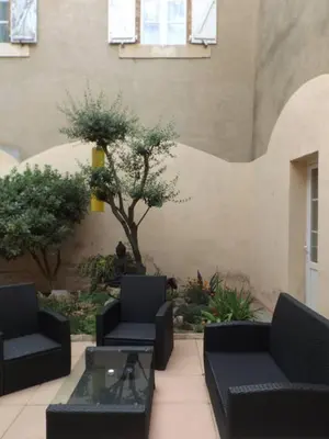 a patio with two couches and a table and a tree at Relais de l'Alaric in Moux