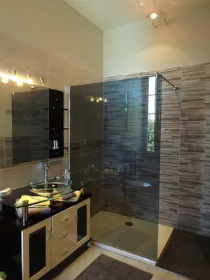 a bathroom with a glass shower with a sink and a tub at Relais de l'Alaric in Moux