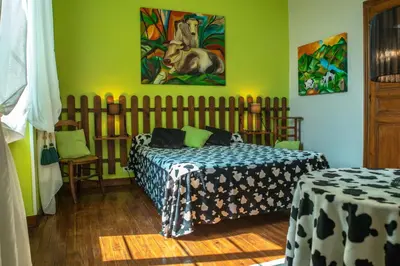 a bedroom with a bed and a table and a painting at Relais de l'Alaric in Moux