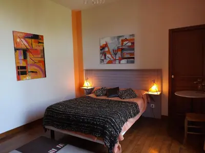a bedroom with a bed and two paintings on the wall at Relais de l'Alaric in Moux
