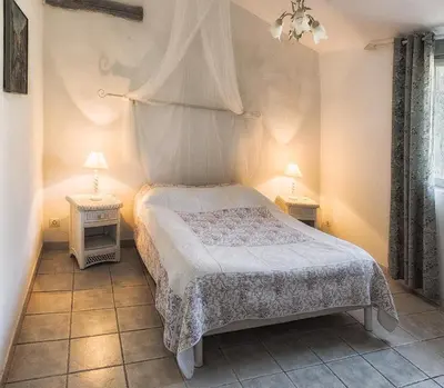 a bedroom with a bed and two tables with lamps at Ecuries Sainte Croix in Carcassonne