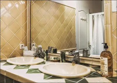 a bathroom with two sinks and a large mirror at Ecuries Sainte Croix in Carcassonne