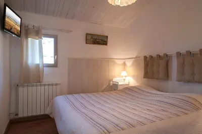 a bedroom with a bed and a window and a television at Ecuries Sainte Croix in Carcassonne