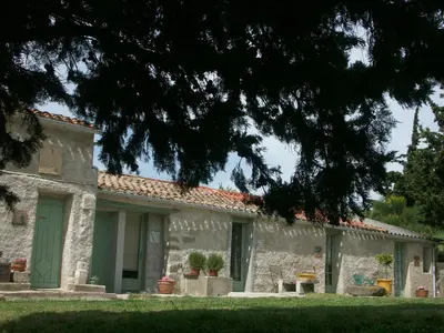 an old stone house with a green door at Ecuries Sainte Croix in Carcassonne