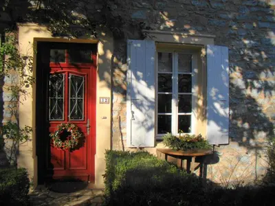 a red door and a window on a house at l'Oulibo in Villeneuve-les-Corbières