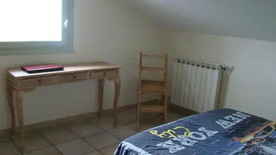 a bedroom with a desk and a chair next to a bed at l'Oulibo in Villeneuve-les-Corbières