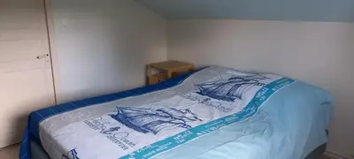 a bed with a blue and white blanket on it at l'Oulibo in Villeneuve-les-Corbières