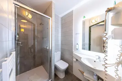 a bathroom with a shower and a toilet and a sink at Hôtel Pont Rouge , Carcassonne in Carcassonne