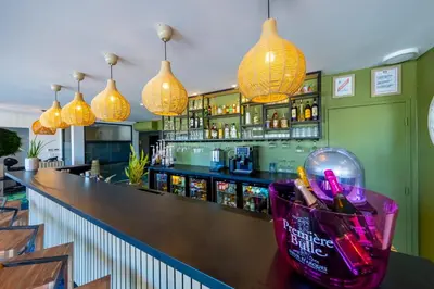 a bar with pendant lights and a counter at Hôtel Pont Rouge , Carcassonne in Carcassonne