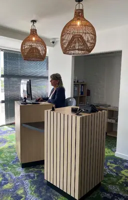 a woman sitting at a desk in an office with a computer at Hôtel Pont Rouge , Carcassonne in Carcassonne