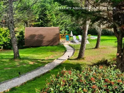 a path in a park with trees and a bench at Belloréade Maison d'hôtes in Belloc