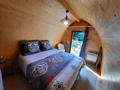 a bedroom with a bed in a log cabin at Belloréade Maison d'hôtes in Belloc