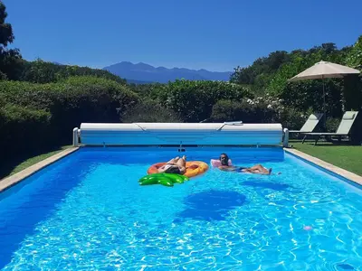 two people are laying in a swimming pool at Belloréade Maison d'hôtes in Belloc
