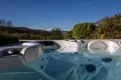 a jacuzzi tub in the backyard of a house at Belloréade Maison d'hôtes in Belloc