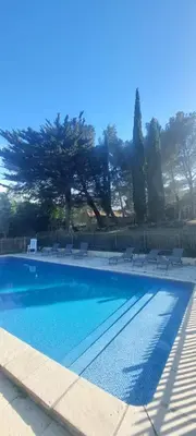 a large swimming pool with chairs and a fence at Mas Montluzia in Cascastel-des-Corbières
