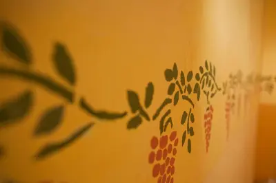 a wall with green leaves painted on it at Mas Montluzia in Cascastel-des-Corbières