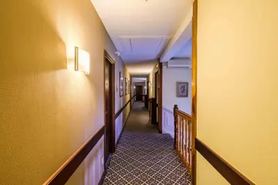 a corridor of a hallway with yellow walls and a hallway at Hôtel l'Aragon in Carcassonne