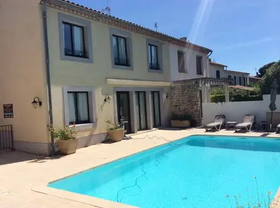 a restaurant with tables and chairs and a kitchen at Hôtel l'Aragon in Carcassonne