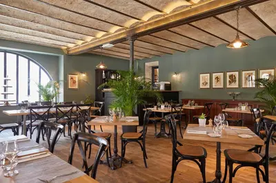 a dining room with wooden tables and chairs at Château Les Carrasses in Capestang