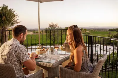 a man and woman sitting at a table with wine glasses at Château Les Carrasses in Capestang
