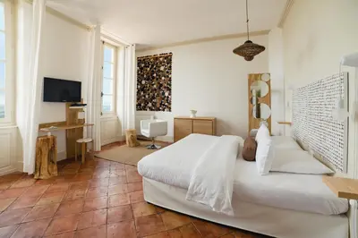 a bedroom with a white bed and a television at Cap de Castel in Puylaurens